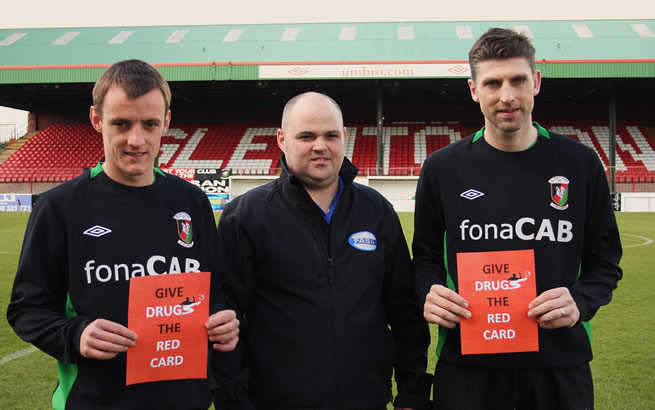 Glentoran’s Jason Hill and Paul Leeman help James Scott from FASA (centre) launch the FASA ‘Give Drugs the Red Card’ Day at the Oval on Saturday 30th April 2011